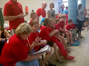 Kinder und Trainer am Beckenrand beim anfeuern