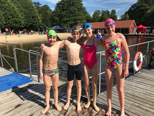 Vier Schwimmer posieren am Beckenrand