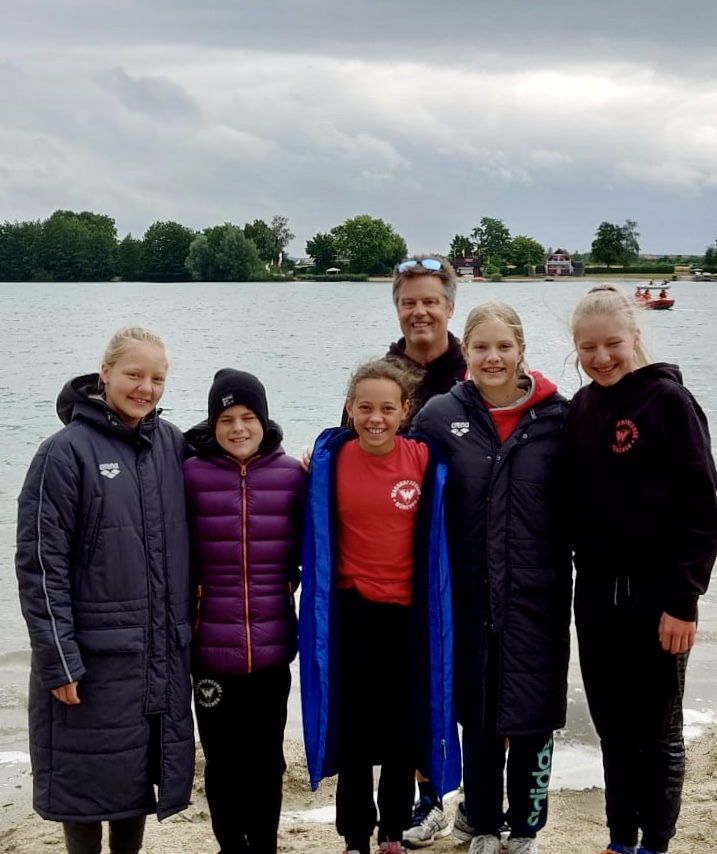 Fünf Schwimmerinnen warm angezogen vor dem See