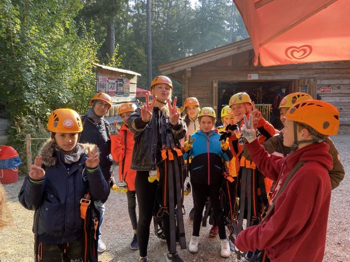 Gruppenfoto mit orangenen Helmen und Peace Zeichen mit den Händen